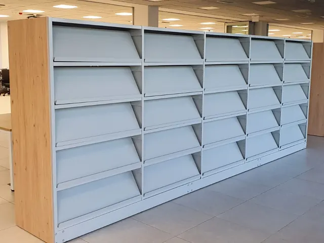 Žemos bibliotekos lentynos šviesioje patalpoje